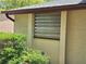 Window view with metal hurricane shutter and manicured landscaping at 4420 Sawgrass Blvd, New Port Richey, FL 34653