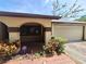 Covered front porch with arched design, brick details, manicured shrubs and security system at 4420 Sawgrass Blvd, New Port Richey, FL 34653