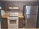 The kitchen features wooden cabinetry, white appliances, and a stainless steel refrigerator at 4420 Sawgrass Blvd, New Port Richey, FL 34653