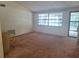 Bright living room featuring large windows, neutral walls, and a secure front door at 4420 Sawgrass Blvd, New Port Richey, FL 34653