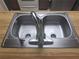 A stainless steel dual sink features a high-rise faucet on a wooden countertop at 4420 Sawgrass Blvd, New Port Richey, FL 34653