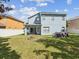 Exterior view of a backyard featuring a fire pit, jacuzzi and covered patio area at 4481 Birchfield Loop, Spring Hill, FL 34609