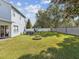 Exterior view of a spacious backyard featuring a jacuzzi, fire pit, and playground at 4481 Birchfield Loop, Spring Hill, FL 34609