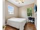 Bedroom featuring a ceiling fan, wood floors, and a large window with views of the lush green landscape at 4481 Birchfield Loop, Spring Hill, FL 34609