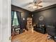 Cozy bedroom with dark-themed decor, hardwood floors, and ample natural light at 4481 Birchfield Loop, Spring Hill, FL 34609