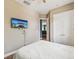 Bedroom featuring wood-look floors, a ceiling fan, and wall-mounted TV at 4481 Birchfield Loop, Spring Hill, FL 34609