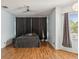 Spacious bedroom featuring hardwood floors, a ceiling fan, and large windows with stylish curtains at 4481 Birchfield Loop, Spring Hill, FL 34609