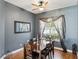 Traditional dining room features hardwood floors, modern ceiling fan, and natural light from the window at 4481 Birchfield Loop, Spring Hill, FL 34609