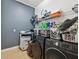 Functional laundry room equipped with washer, dryer, and storage shelves at 4481 Birchfield Loop, Spring Hill, FL 34609
