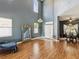 Spacious living room with high ceilings, wood floors, a large window and elegant decor at 4481 Birchfield Loop, Spring Hill, FL 34609