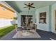 Covered patio with ceiling fan, table and chairs overlooking the backyard at 4481 Birchfield Loop, Spring Hill, FL 34609