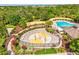 Aerial view of the splash pad with colorful water features, seating, and landscaping, alongside a pool and playground at 4481 Birchfield Loop, Spring Hill, FL 34609