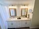 Modern bathroom featuring double sinks, granite countertops, and wood-look tile floors at 4702 Portland Manor Dr, New Port Richey, FL 34655