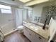 Bright bathroom with a walk-in shower, wood-style flooring, and a granite countertop vanity at 4702 Portland Manor Dr, New Port Richey, FL 34655