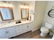 Modern bathroom featuring double sinks, granite countertops, and wood-look tile floors at 4702 Portland Manor Dr, New Port Richey, FL 34655