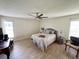 Comfortable bedroom featuring wood-look floors, neutral colors, and a ceiling fan at 4702 Portland Manor Dr, New Port Richey, FL 34655