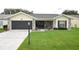 Charming one-story home with a well-manicured lawn, stone accents, and a spacious driveway leading to a two-car garage at 4702 Portland Manor Dr, New Port Richey, FL 34655
