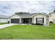 Inviting single-story home featuring stone accents, a well-kept lawn, and a two-car garage at 4702 Portland Manor Dr, New Port Richey, FL 34655