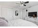 Bright bedroom features a ceiling fan, dresser with a television, and a closet with sliding doors at 5321 Mosaic Dr, Holiday, FL 34690