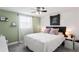 Cozy bedroom with accent wall, queen sized bed, stylish nightstand, and ceiling fan at 5321 Mosaic Dr, Holiday, FL 34690