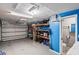 Spacious garage interior featuring a roll-up door, shelving, and convenient access to a bathroom at 5321 Mosaic Dr, Holiday, FL 34690