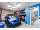 Well-organized garage interior with a car parked, shelving, and a bathroom with laundry at 5321 Mosaic Dr, Holiday, FL 34690