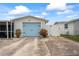 Charming single-story home featuring a light blue garage door, brick exterior, and well-maintained landscaping at 5321 Mosaic Dr, Holiday, FL 34690
