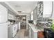 Open kitchen with white appliances, granite countertops, wine rack and views of the dining room at 5321 Mosaic Dr, Holiday, FL 34690