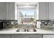 Kitchen sink with a bright window, custom cabinets, stainless steel appliances, and granite countertops at 5321 Mosaic Dr, Holiday, FL 34690