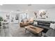 Spacious living room with hardwood floors, an inviting book case, and a glimpse into the modern kitchen at 5321 Mosaic Dr, Holiday, FL 34690