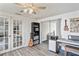 Well-lit room showcasing French doors, hardwood floors, ceiling fan, and sliding doors to the outdoor patio at 5321 Mosaic Dr, Holiday, FL 34690