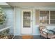 Enclosed porch featuring a cozy chair, potted plants, and a stylish white door at 5321 Mosaic Dr, Holiday, FL 34690