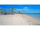 A scenic view of the beach with white sand, palm trees, and blue skies at 5339 Bowline Bnd, New Port Richey, FL 34652