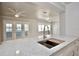 Bright kitchen showcasing a large island with white countertop, stainless faucet and view to a living area at 5339 Bowline Bnd, New Port Richey, FL 34652