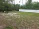 Expansive backyard space surrounded by lush trees and a white privacy fence at 5373 Frost Rd, Spring Hill, FL 34606