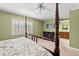 Bedroom showcasing a four poster bed, bathroom access and a flat screen TV at 5502 Bluejay Ln, Tampa, FL 33625