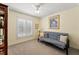 Bright bedroom with a futon, ceiling fan, and window with white shutters at 5502 Bluejay Ln, Tampa, FL 33625