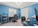 Bright home office with blue walls, sleek glass desks, and ample shelving for an organized workspace at 5502 Bluejay Ln, Tampa, FL 33625