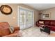Cozy living room with tile flooring, access to the outdoors, and a decorative wall clock at 5502 Bluejay Ln, Tampa, FL 33625