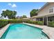 Backyard featuring an in-ground pool with stone pavers and lush, trimmed greenery at 5502 Bluejay Ln, Tampa, FL 33625