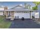 Charming home featuring stone accents, a metal roof, and a freshly paved driveway leading to an attached two-car garage at 5520 Fulmar Dr, Tampa, FL 33625