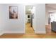 Hallway with hardwood floors leading to the kitchen with white cabinets and stainless-steel appliances at 5520 Fulmar Dr, Tampa, FL 33625