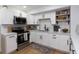 Modern kitchen with white cabinetry, black hardware, stainless steel appliances, and wood floors at 5520 Fulmar Dr, Tampa, FL 33625