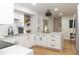 Well-lit kitchen with white cabinetry, modern fixtures, an island, and open shelving that enhance functionality at 5520 Fulmar Dr, Tampa, FL 33625
