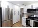 Bright kitchen featuring stainless steel appliances, white cabinetry and sleek hardwood floors at 5520 Fulmar Dr, Tampa, FL 33625