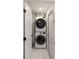 Narrow laundry room features a stacked washer and dryer set, maximizing space efficiency at 5520 Fulmar Dr, Tampa, FL 33625