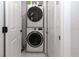 Compact laundry room featuring a stacked washer and dryer set, maximizing space efficiency at 5520 Fulmar Dr, Tampa, FL 33625