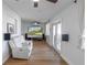 Cozy living room featuring wood flooring, a ceiling fan, and french doors that bring in tons of natural light at 5520 Fulmar Dr, Tampa, FL 33625