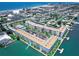 Aerial view of a waterfront condo complex with boat docks, pool, and parking, near the beach in a coastal neighborhood at 5555 Gulf Blvd # 315, St Pete Beach, FL 33706