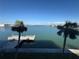 Beautiful waterfront views with a private dock surrounded by palm trees on a sunny day at 5555 Gulf Blvd # 315, St Pete Beach, FL 33706